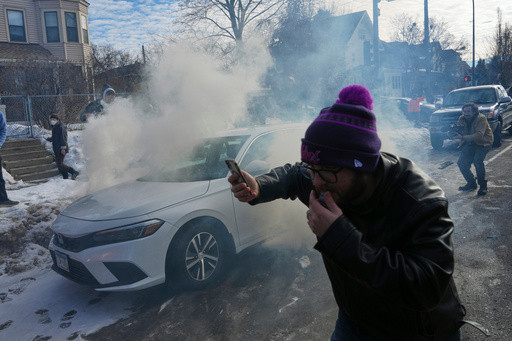Crowd yells ‘cowards!’ after federal agents crash into a car and fire tear gas in Minneapolis