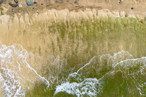 Early Hawaiian petroglyphs on a beach are visible again with changing tides and shifting sands