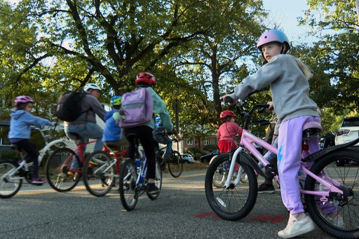 From a few to more than 350, children and parents ride together to school as a ‘bike bus’