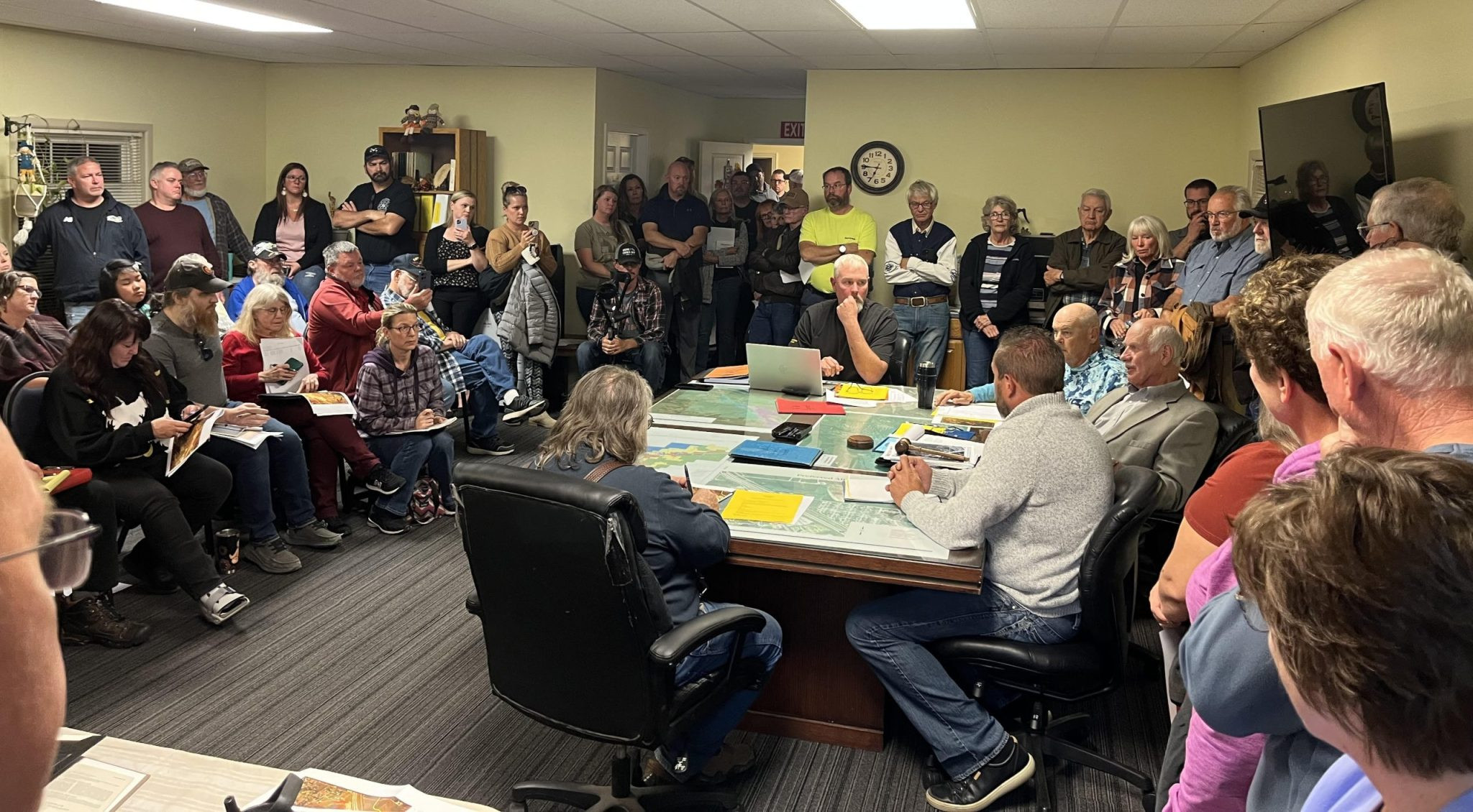 Concerned citizens, businesses, and legislators gather together to voice opposition to planned gravel pit