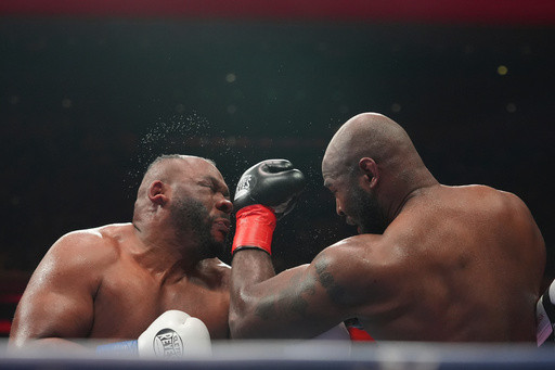 Boxer Jarrell Miller has his hairpiece knocked upward by a punch, then throws it into the crowd