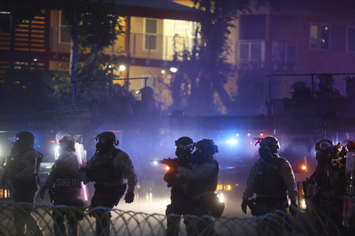 After tear gas and street fires, a Los Angeles community cleans up as National Guard troops arrive